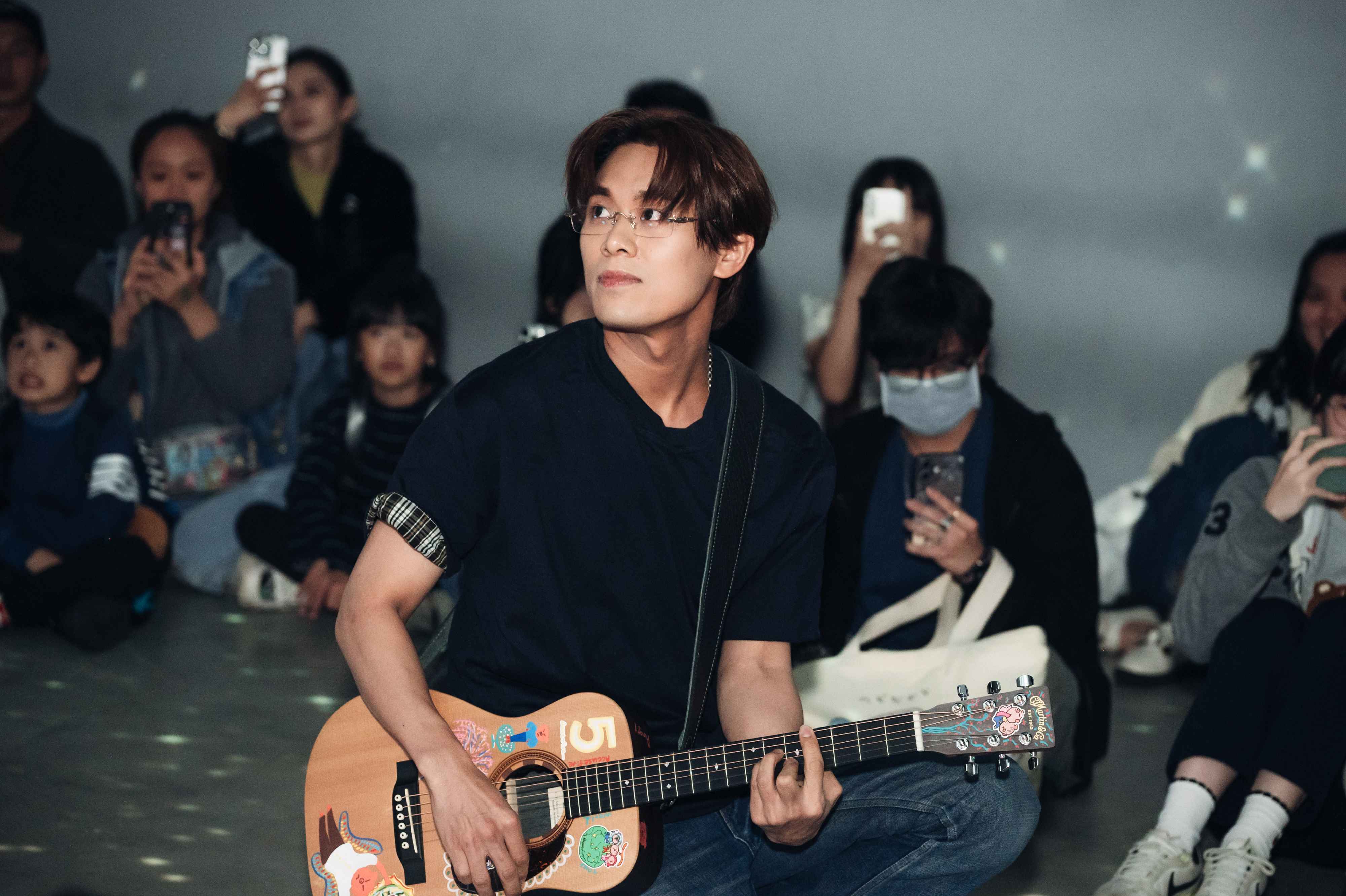 告五人主唱兼吉他手雲安於展區演出，邊自彈自唱邊望向演唱會影像。圖/北流提供